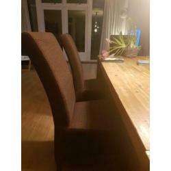 4 donkerbruine eettafelstoelen.